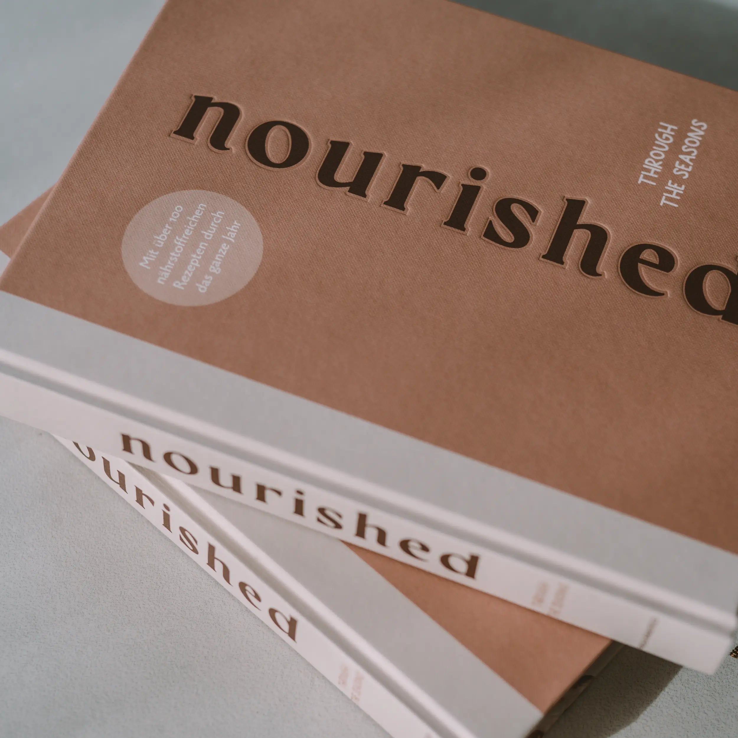 Zwei übereinander liegende Kochbücher mit Rezepten für traditionelle und saisonale Gerichte.